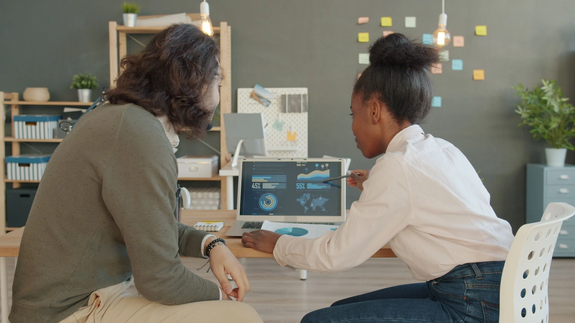 Two colleagues reviewing data together on a laptop