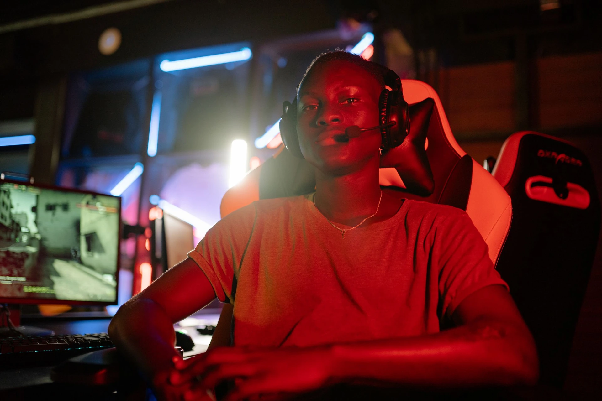 An adult gamer wearing headphones at a real gaming setup