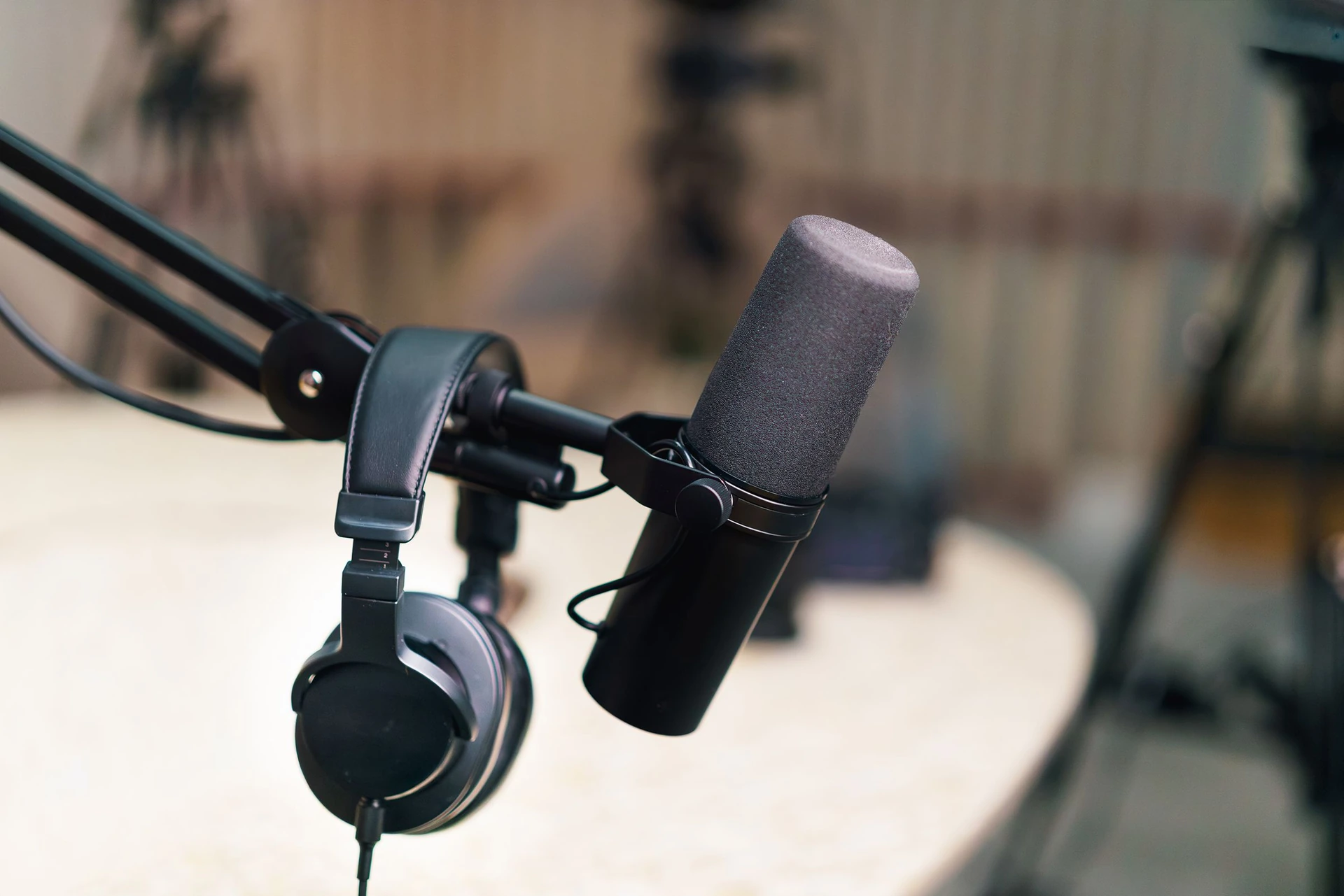 A real recording microphone and headphones on a studio boom arm